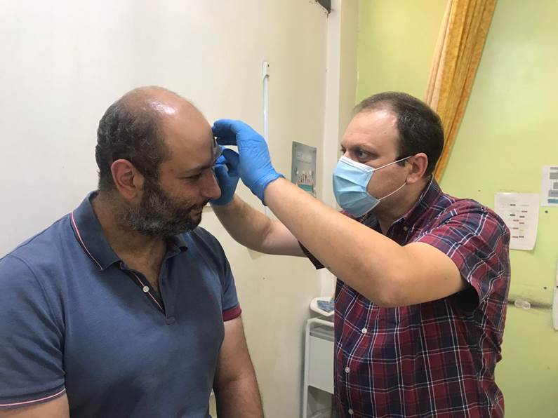 Dr Dany, au dispensaire de Tahaddi, change son pansement.